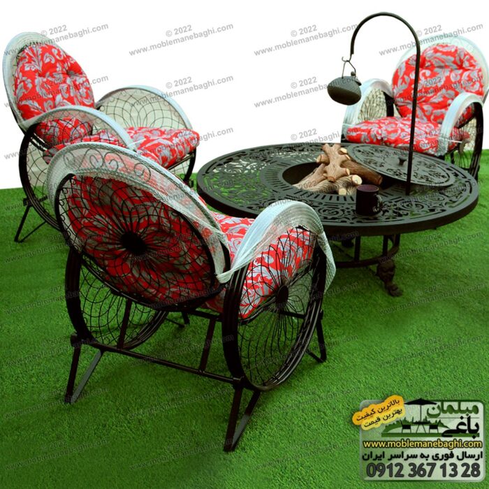میز آتشدان گرد به همراه ست مبلمان باغی صندلی فلزی مدل گلبرگ یا کالسکه مخصوص فضای باز باغ و ویلا با تشک قرمز بر روی چمن مصنوعی