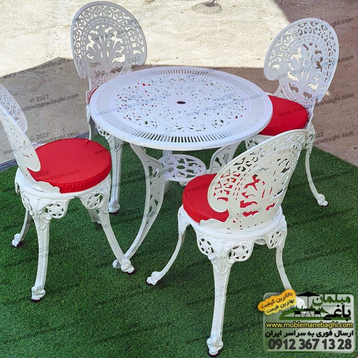 ست چهار نفره میز و صندلی آلومینیومی نهار خوری مدل طاووسی 2021 رنگ سفید به همراه تشک قرمز برروی چمن مصنوعی در محوطه مرکز پخش صندلی آلومینیومی فروشگاه مبلمان باغی