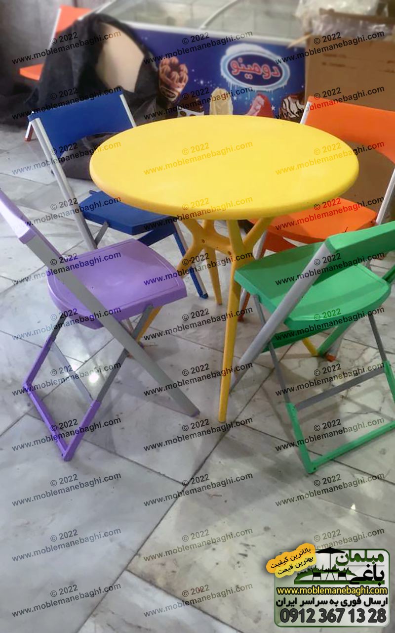 ست چهار نفره ناهارخوری شامل چهار صندلی تاشو پایه آلومینیومی مقاوم مناسب رستوران،کافه و مسافرت در رنگ های شاد سبز، بنفش، نارنجی و آبی به همراه میز پلیمری پلاستیکی زرد رنگ در رستورانی زیبا در مارلیک کرج