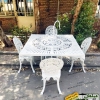 ست میز آتشدان گازی مدرن و صندلی آلومینیومی طاووسی به رنگ سفید در محوطه فضای باز باغی زیبا و قدیمی