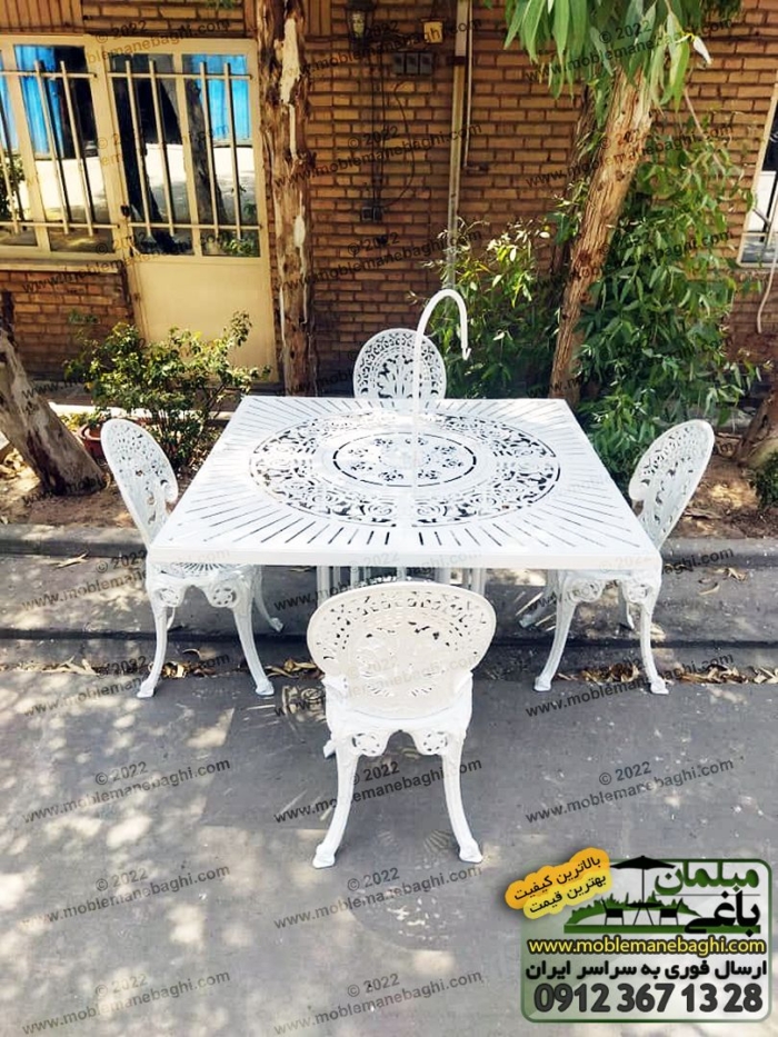 ست میز آتشدان گازی مدرن و صندلی آلومینیومی طاووسی به رنگ سفید در محوطه فضای باز باغی زیبا و قدیمی