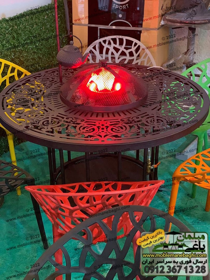 میز آتشدان گرد پایه بلند به همراه درب منقل آتشدان و نگهدارنده کتری. میز آتشدان به عنوان میز ناهارخوری فضای باز در ست مبلمان باغی به همراه صندلی مدل درختی.