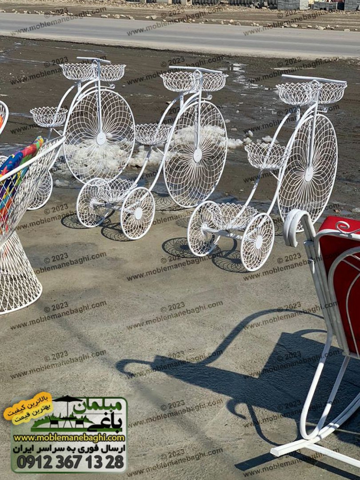 استند گلدان فلزی طرح دوچرخه دارای چهار پایه گلدانی واقع در محوطه فضای باز فروشگاه مبلمان باغی