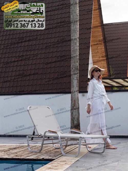 خانمی ایستاده در کنار تخت استخری سانرایز مدل پرنیان به رنگ سفید در کنار استخری زیبا در یک ویلای لاکچری
