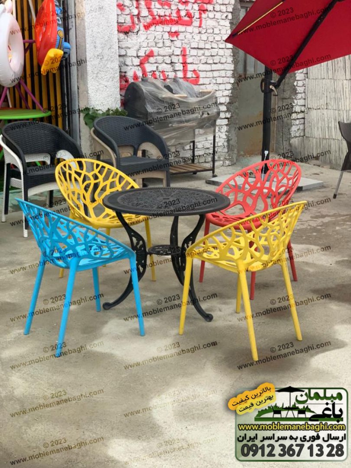 صندلی درختی مخصوص فضای باز و رستوران با رنگ‌های زرد و قرمز و آبی و میز آلومینیومی واقع در محوطه فروشگاه مبلمان باغی در کرج